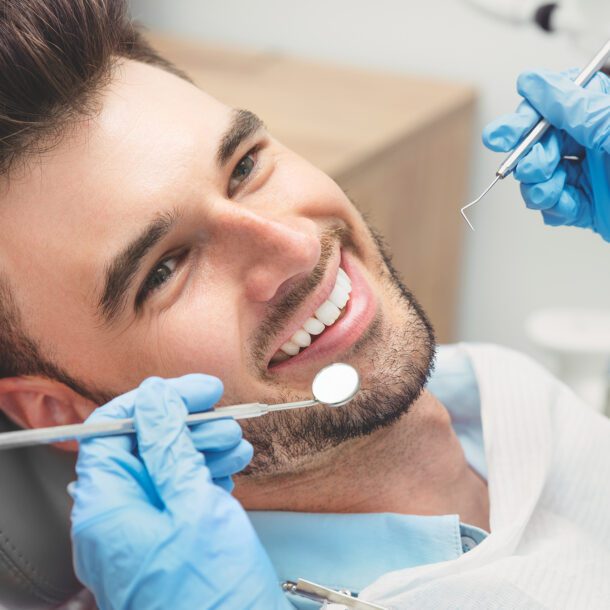 Mężczyzna badający zęby u dentysty Gabinet stomatologiczny Dr Frank - Warszawa Mokotów
